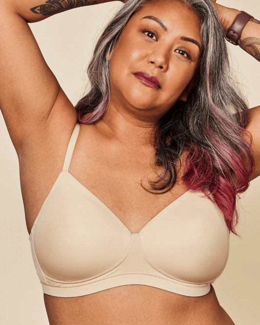 Woman wearing a beige bra against a beige background