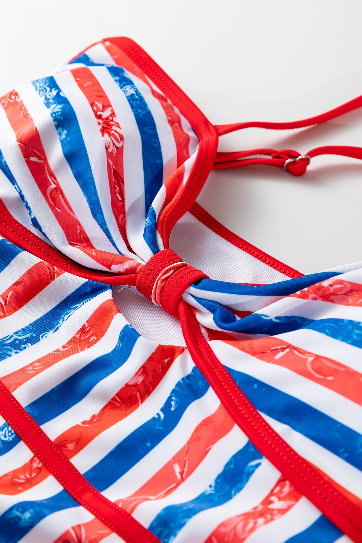 Red, white, and blue striped bikini top on a white background