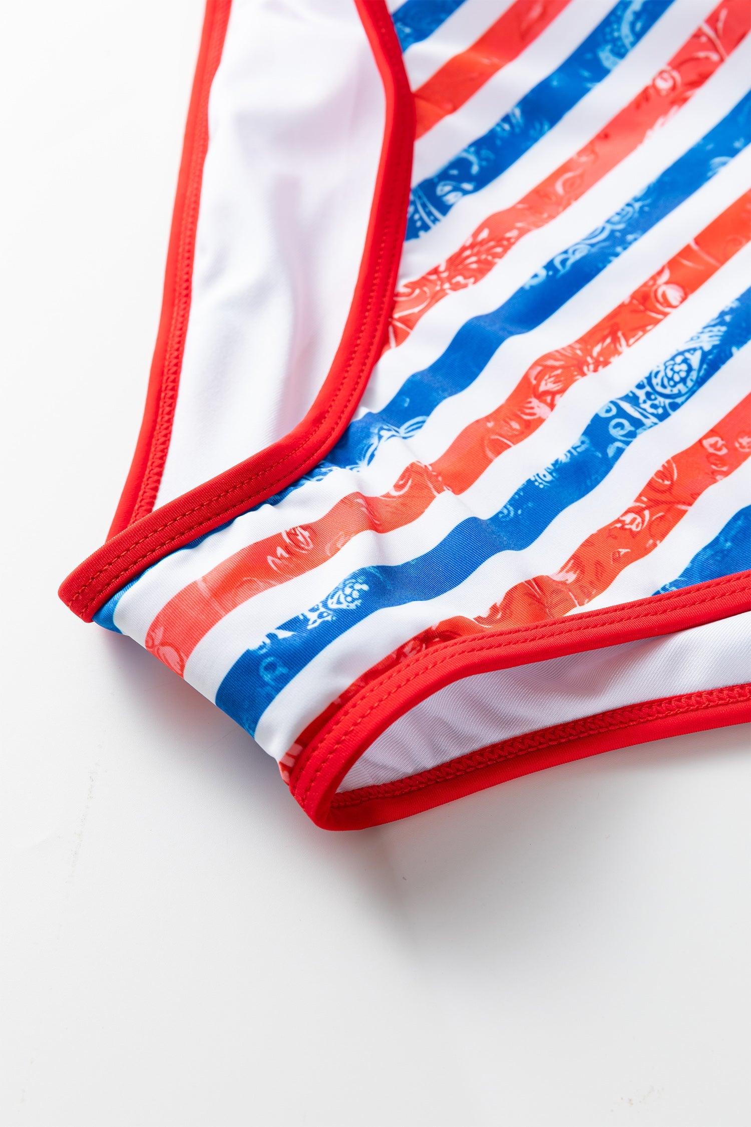 Close-up of a bikini bottom with red, white, and blue stripes on a white background