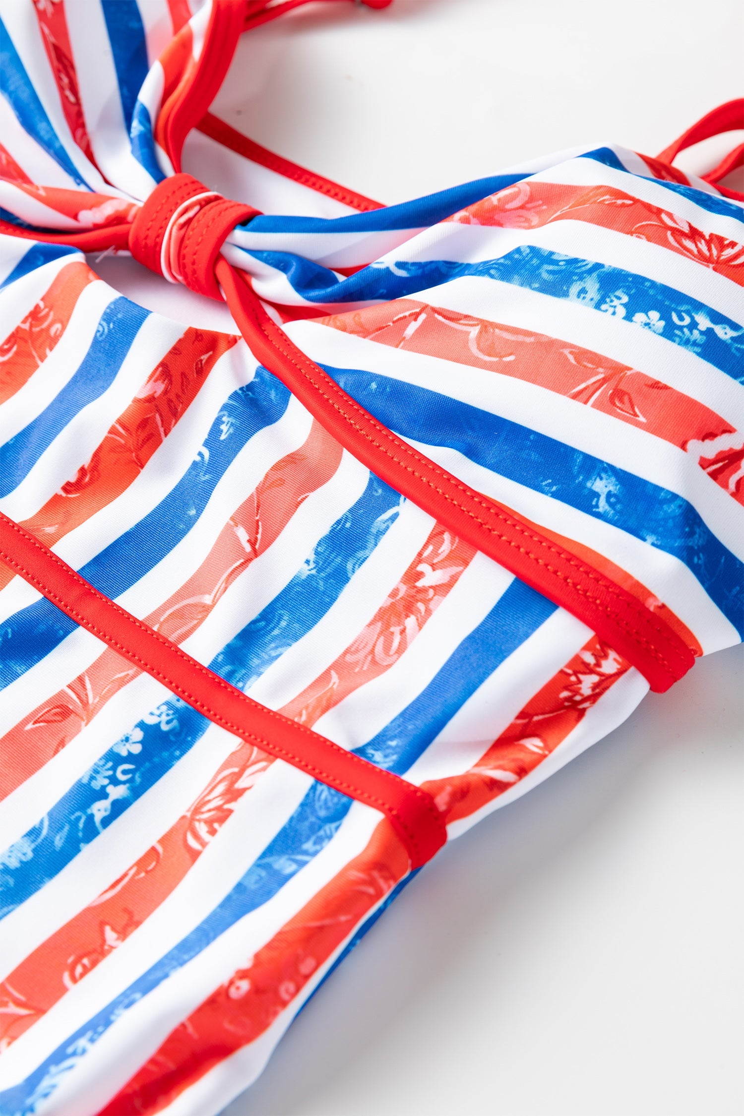 Red, white, and blue striped bikini top on a white background