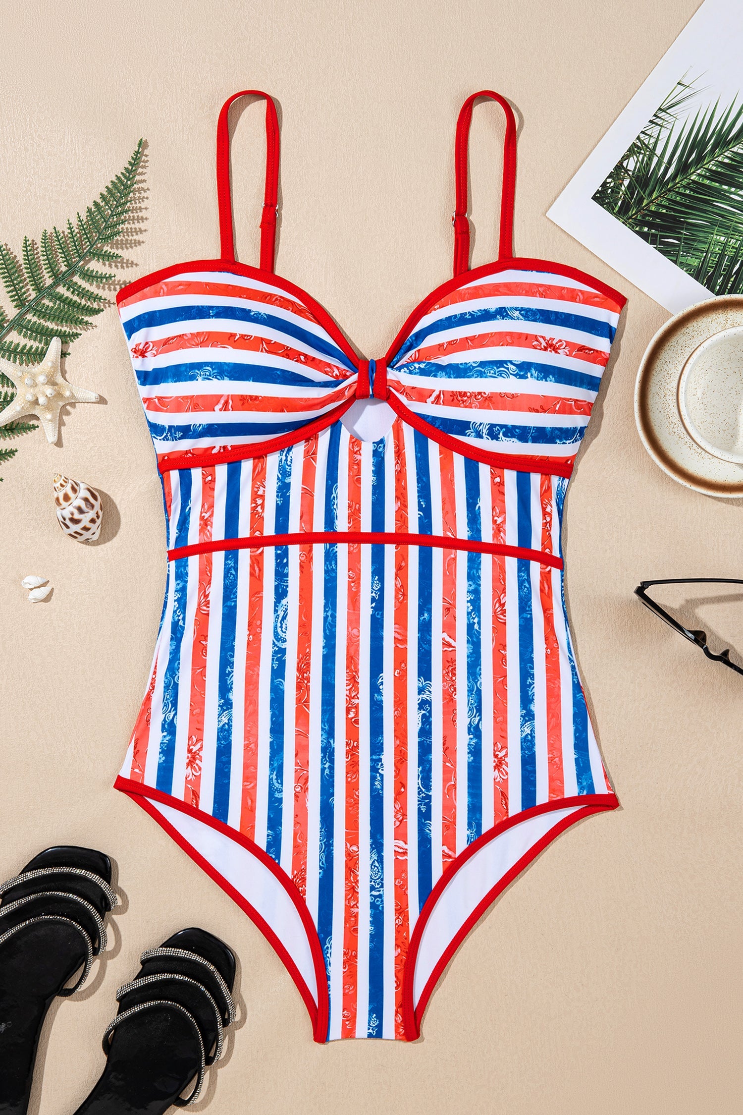 Striped swimsuit with red, white, and blue pattern on a beige surface.