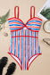 Striped swimsuit with red, white, and blue pattern on a beige surface.